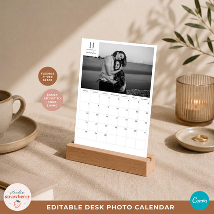 Editable monthly photo calendar displayed in a wooden desk stand with a black and white couple photograph and clean calendar grid.